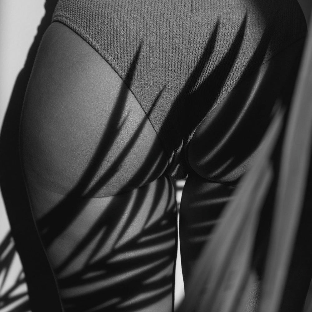 Black and white photo of backside with leaf shadow